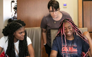 Ashleen Williams, instructional assistant professor in the Office of the Provost, works with two students in the Good Life pilot summer program.